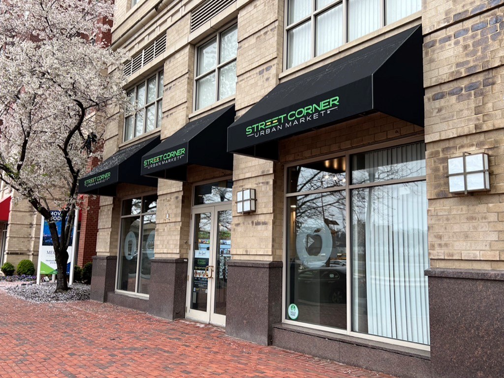 A building with a black awning that says Street Corner.