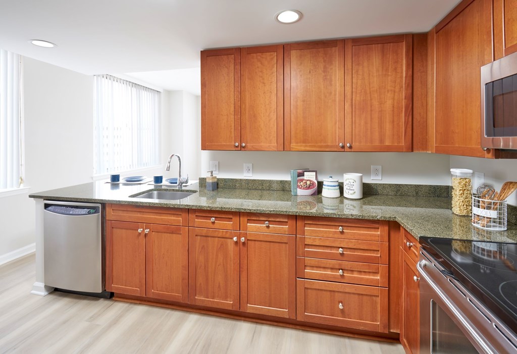 A kitchen with wooden cabinets and a granite countertop.