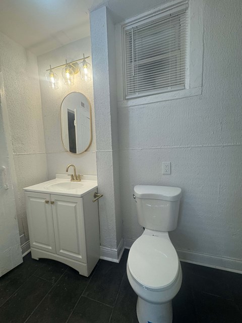 A white toilet sits next to a sink in a small bathroom.