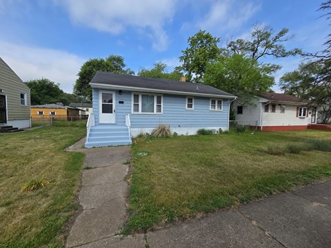 A blue house with a white door and a small porch.