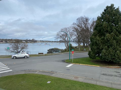 A car is stopped at a stop sign at a four-way intersection.