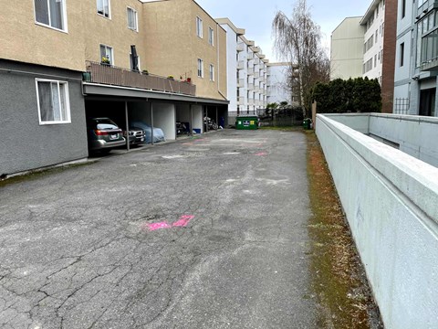 A parking lot with a pink line painted on the pavement.