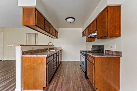 A kitchen with wooden cabinets and a black stove top oven.