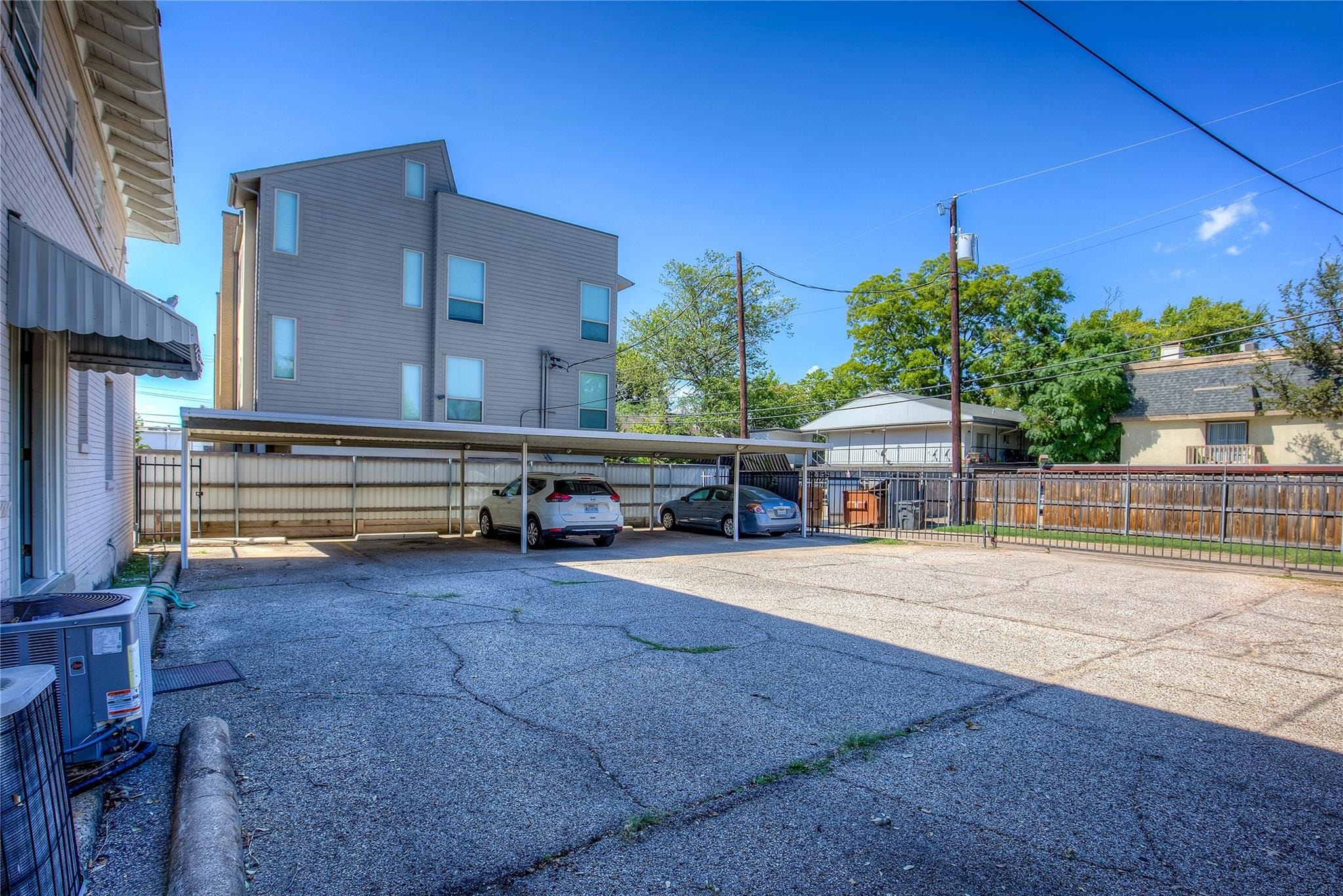 A parking lot with a building and cars parked in front.