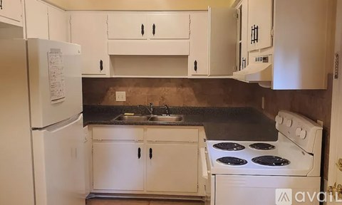 A kitchen with white cabinets and a white stove.