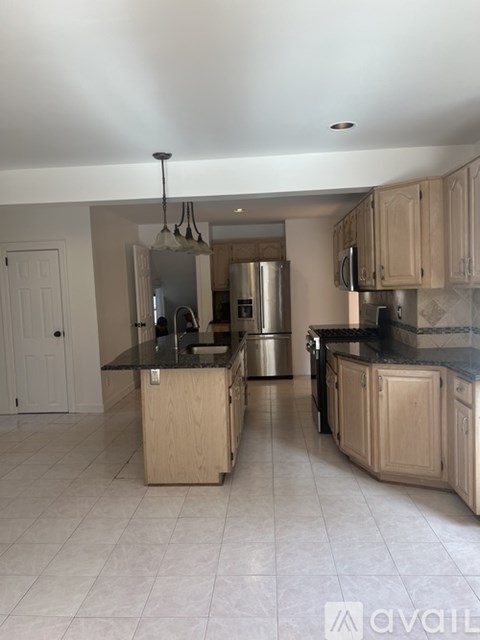 A kitchen with wooden cabinets and a black countertop.