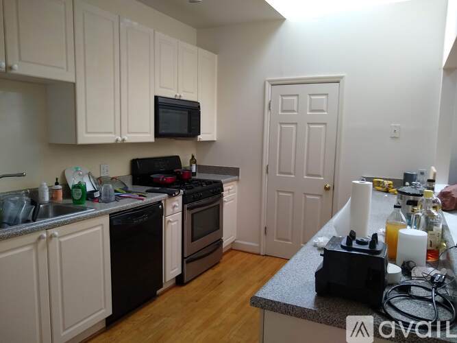 A kitchen with white cabinets and black appliances.