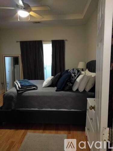 A bedroom with a bed, pillows, and a ceiling fan.