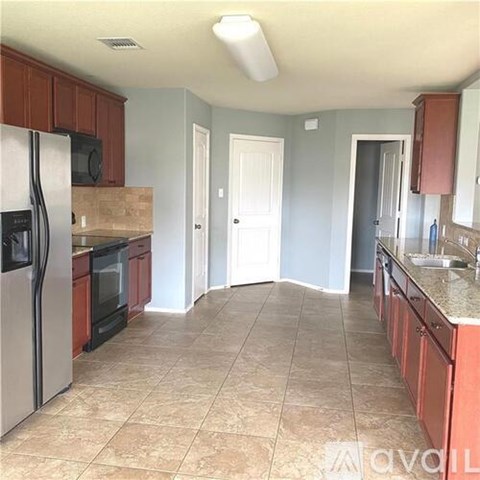 A kitchen with a refrigerator, microwave, and oven.