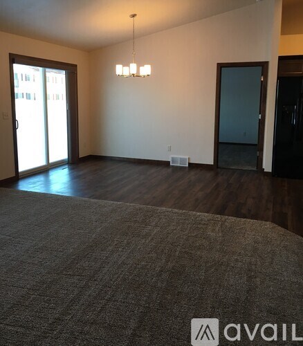A room with a carpet and a chandelier.