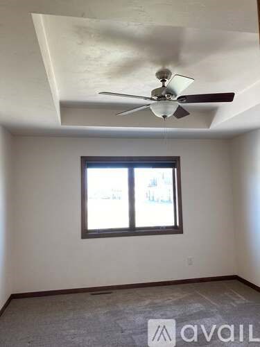A room with a ceiling fan and a window.