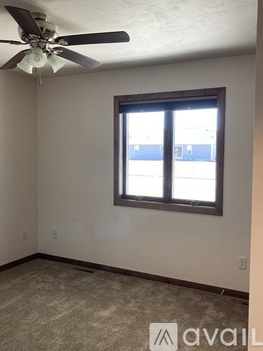 A room with a ceiling fan and a window.