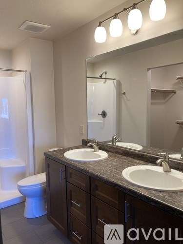 A bathroom with a toilet, sink, and mirror.