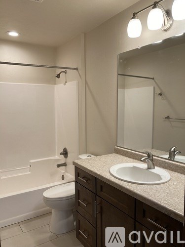 A bathroom with a toilet, sink, and mirror.