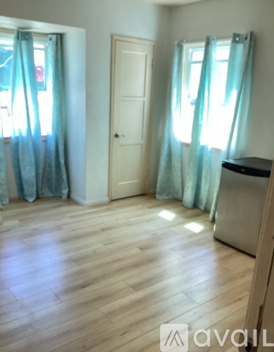 A room with a wooden floor and a white door.