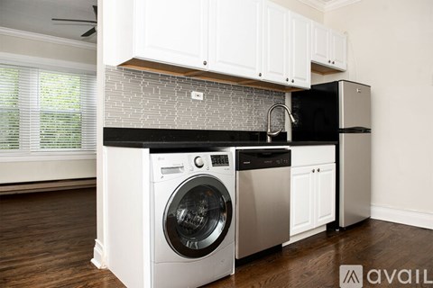 A modern kitchen with a washing machine and a black countertop.