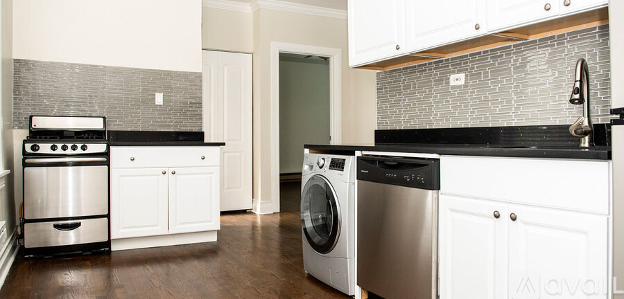 A modern kitchen with white cabinets and a black countertop.