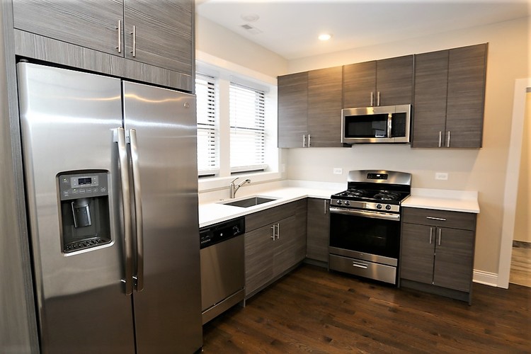A modern kitchen with a stainless steel refrigerator and oven.