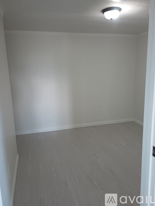 A room with a light on the ceiling and a door on the right.