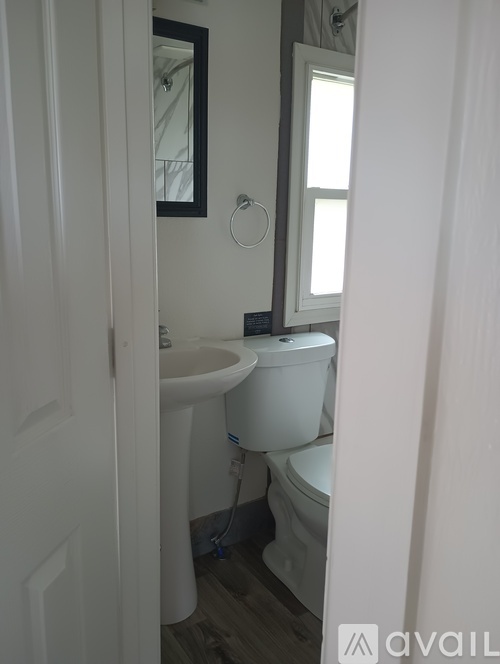 A white toilet sits next to a sink in a small bathroom.