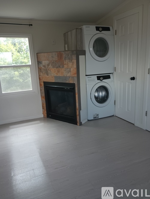 A room with a washer and dryer stacked on top of each other.