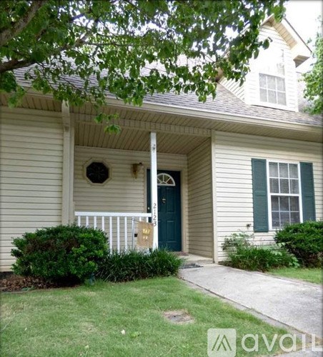 A house with a green door and a window with green shutters.