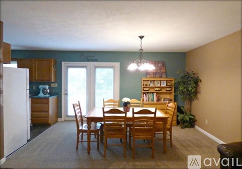 A dining room with a table and chairs.