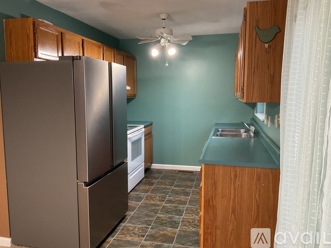 A kitchen with a refrigerator, oven, and sink.