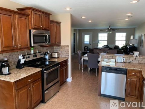A kitchen with wooden cabinets and a stainless steel dishwasher.