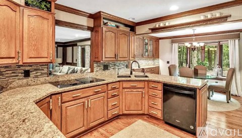 A kitchen with wooden cabinets and a stone countertop.
