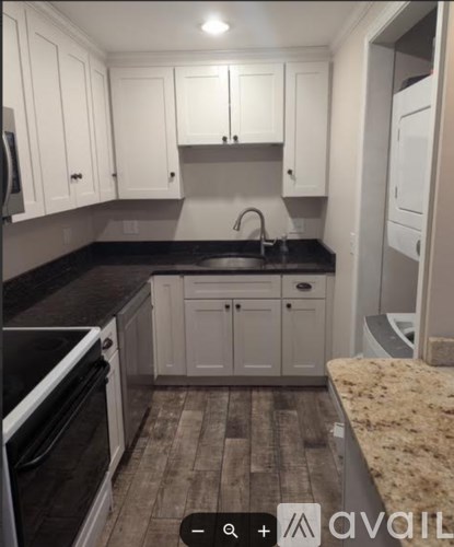 A kitchen with black countertops and white cabinets.