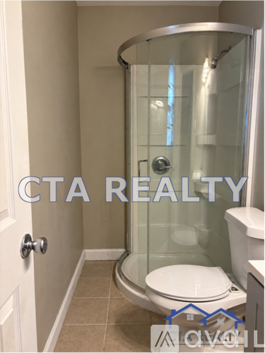 A bathroom with a glass shower stall and a toilet.