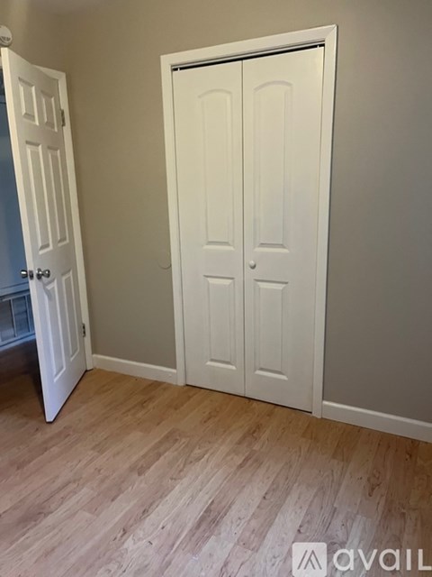 A white door in a room with wooden flooring.