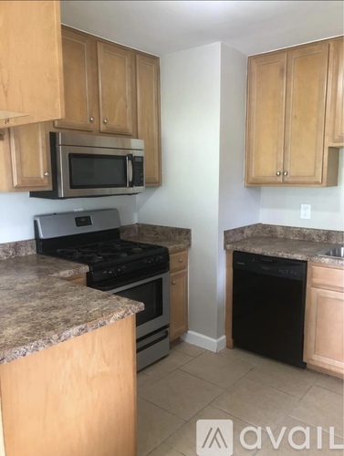 A kitchen with wooden cabinets and granite countertops.