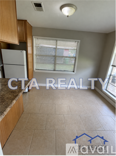 A kitchen with a granite countertop and a refrigerator.