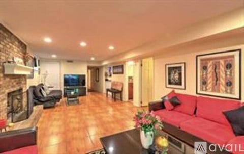 A living room with a red couch and a fireplace.