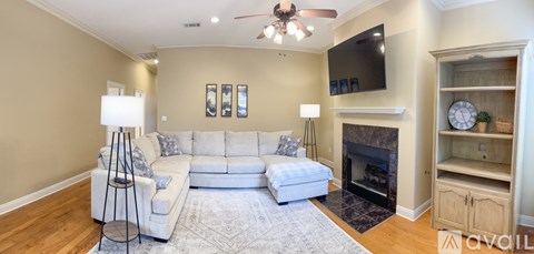 A living room with a white couch and a fireplace.