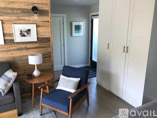 A living room with a blue chair and a wooden table.