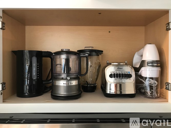A kitchen appliance drawer with a coffee maker, a blender, a toaster, and a mixer.