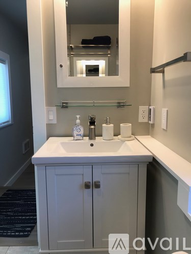 A bathroom with a white sink and a mirror above it.