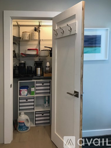 A white door opens to a small kitchen pantry with a lot of storage space.