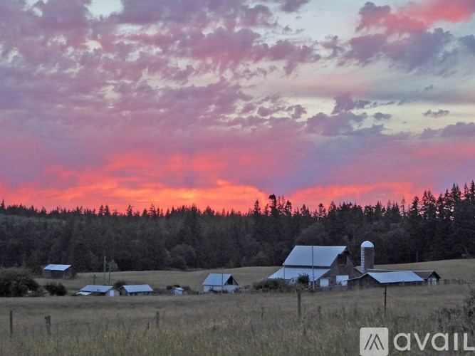 A pastoral scene with a barn and a field.