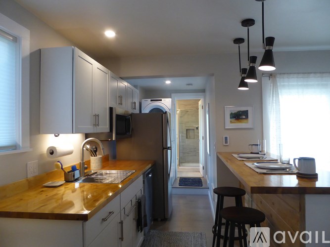 A kitchen with a wooden counter top and a refrigerator.