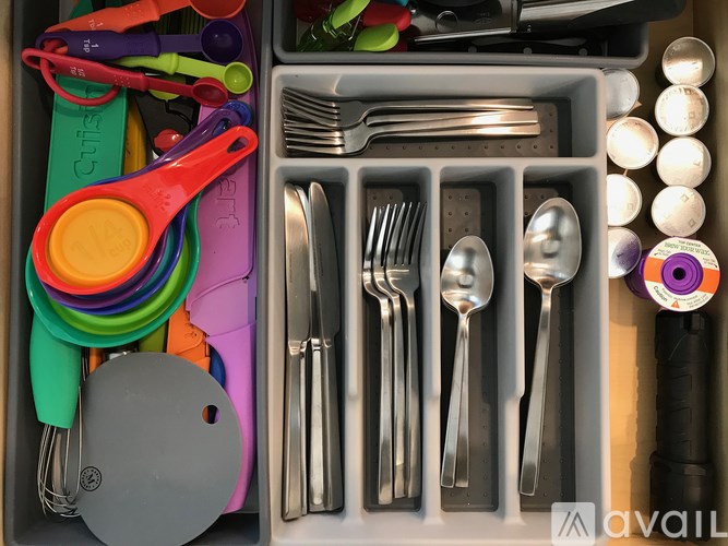 A drawer full of silverware and other kitchen utensils.