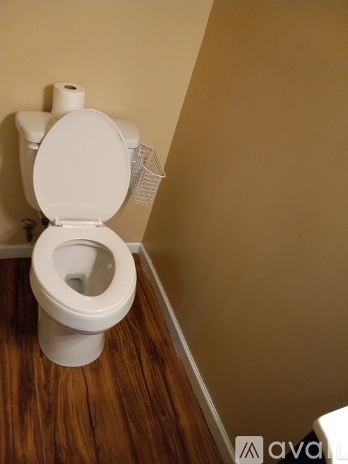 A white toilet with the seat up in a small bathroom.