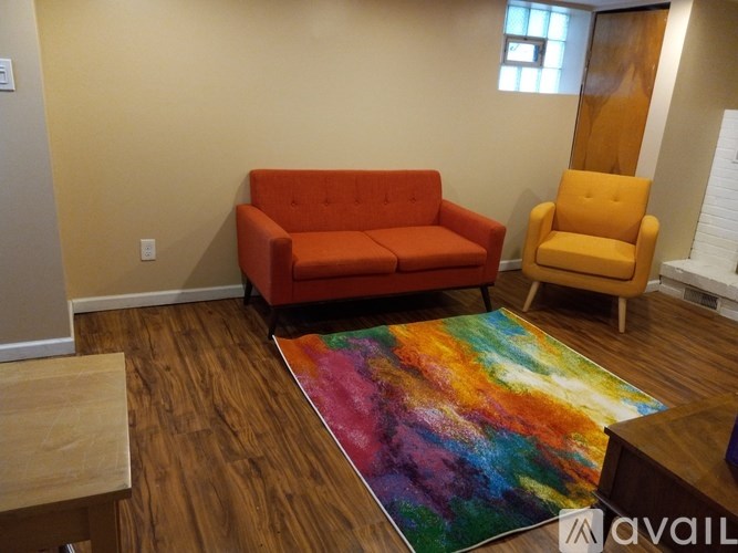 A living room with a red couch and a yellow chair.
