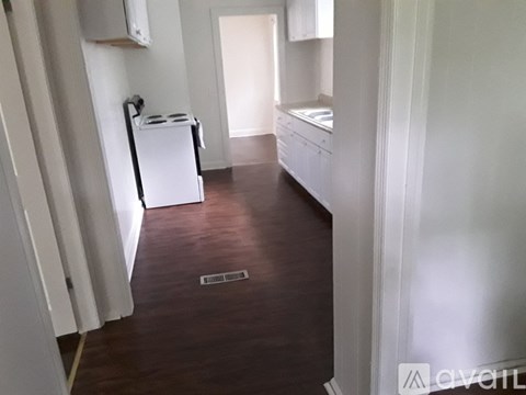 A kitchen with white cabinets and a white fridge.
