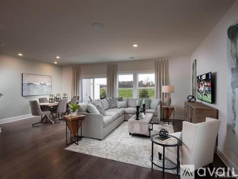 A modern living room with a grey sofa, a wooden coffee table, and a large painting on the wall.