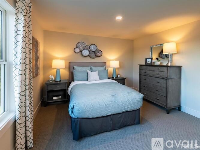 A bedroom with a bed, two nightstands, and a dresser.