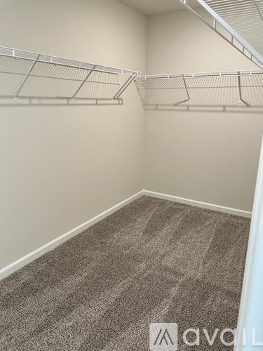 A room with a carpeted floor and a metal shelving unit.